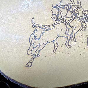 Cowboy roping bull engraved in leather